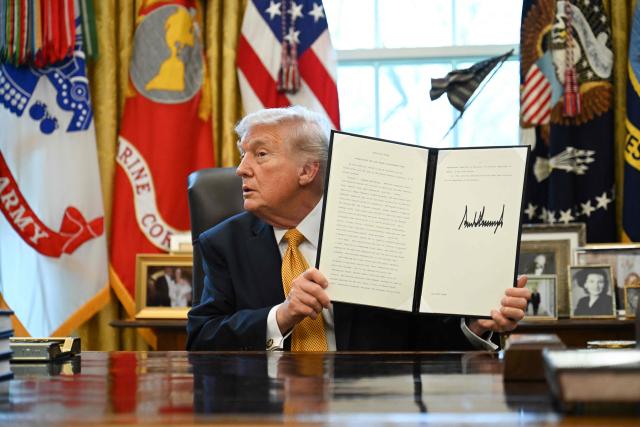 US President Donald Trump displays an executive order on fraud he signed in the Oval Office at the White House in Washington, DC, on March 16, 2026. (Photo by ANNABELLE GORDON / AFP)