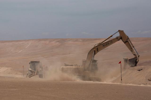 This view shows heavy machinery operating near the Chacalluta border post along the Chile–Peru border on March 16, 2026. Chile's President Jose Antonio Kast launched a border trench project to curb illegal migration. (Photo by Patricio BANDA / AFP)