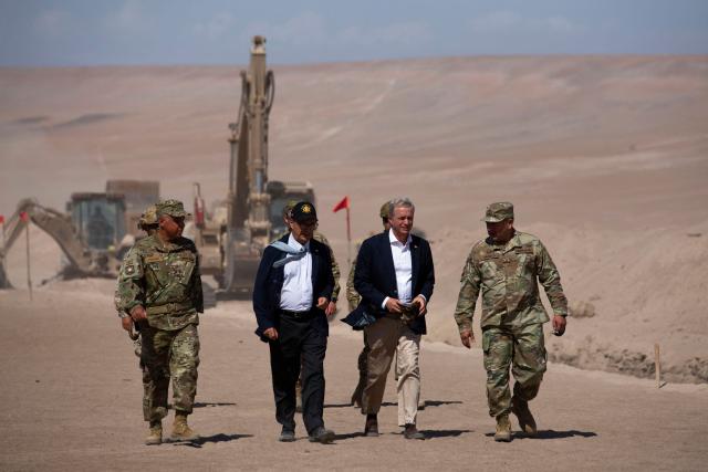Chile’s President Jose Antonio Kast (2nd R), Chilean Defense Minister Fernando Barros (2nd L) and Chilean Army Commander in Chief Pedro Varela (R) walk next to heavy machinery operating near the Chacalluta border post along the Chile–Peru border on March 16, 2026. Kast launched a border?trench project to curb illegal migration (Photo by Patricio BANDA / AFP)
