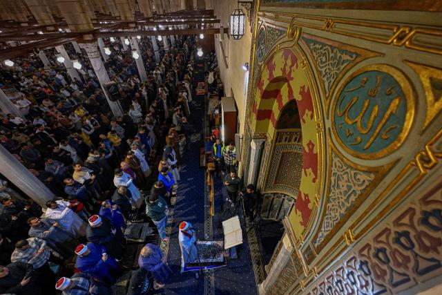 Muslims chant the Tarawih recitations on the occasion of Laylat al-Qadr which falls on the 27th day of the fasting month of Ramadan, at Cairo's Amr Ibn al-Aas mosque late on March 16, 2026. Laylat al-Qadr, or Night of Destiny, marks the night Muslims believe the first verses of the Koran were revealed to the Prophet Mohammed through the archangel Gabriel. (Photo by Khaled DESOUKI / AFP)