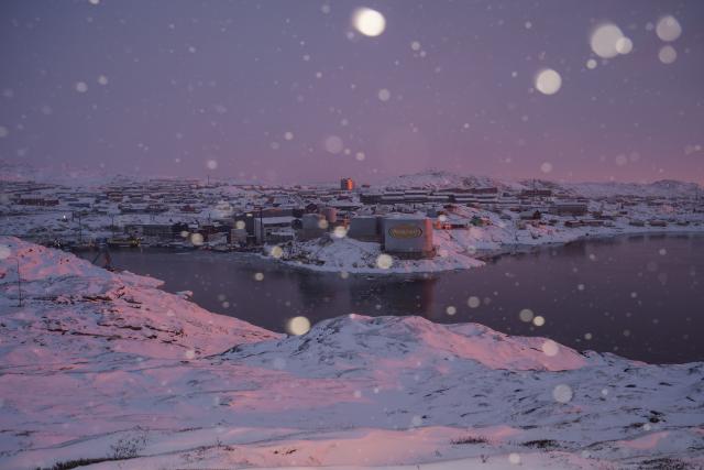 This photograph shows the city of Ilulissat during a sunset, as snow falls, in Ilulissat, Greenland, on March 16, 2026. (Photo by Florent VERGNES / AFP)