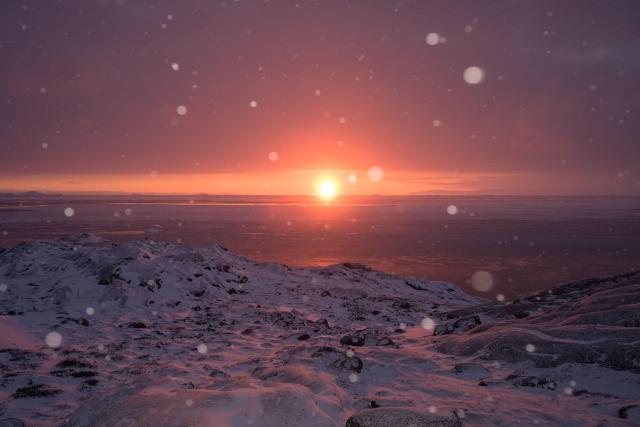 TOPSHOT - This photograph shows a sunset as snow falls, in Ilulissat, Greenland, on March 16, 2026. (Photo by Florent VERGNES / AFP)