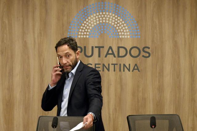 Argentine deputy Maximiliano Ferraro talks on his phone before a press conference of the committee of inquiry into the Libra case ($LIBRA "cryptogate") involving Argentina’s President Javier Milei, his sister, Argentina’s Secretary General of the Presidency Karina Milei, presidential advisor Santiago Caputo and businessman Mauricio Novelli, at the Congress in Buenos Aires on March 16, 2026. The investigation is to examine whether Milei engaged in fraud or criminal association or was in breach of his duties when he praised the $LIBRA cryptocurrency on social media on February 2025. (Photo by JUAN MABROMATA / AFP)