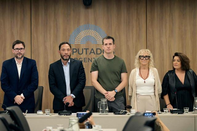 (L-R) Argentine former deputy Oscar Agost Carreno; deputies Maximiliano Ferraro, Juan Marino, Monica Frade, and Sabrina Selva; and members of the committee of inquiry into the Libra case ($LIBRA "cryptogate") involving Argentina’s President Javier Milei, his sister, Argentina’s Secretary General of the Presidency Karina Milei, presidential advisor Santiago Caputo and businessman Mauricio Novelli, pose foir a picture before delivering a press conference at the Congress in Buenos Aires on March 16, 2026. The investigation is to examine whether Milei engaged in fraud or criminal association or was in breach of his duties when he praised the $LIBRA cryptocurrency on social media on February 2025. (Photo by JUAN MABROMATA / AFP)