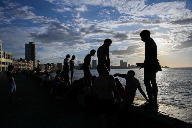 People wait at a bus stop in Havana during a blackout on March 16, 2026. Cuba suffered a widespread power cut on March 16, 2026, according to the national electricity company, against the backdrop of a severe crisis on the island caused by the US energy blockade. (Photo by Yamil LAGE / AFP)
