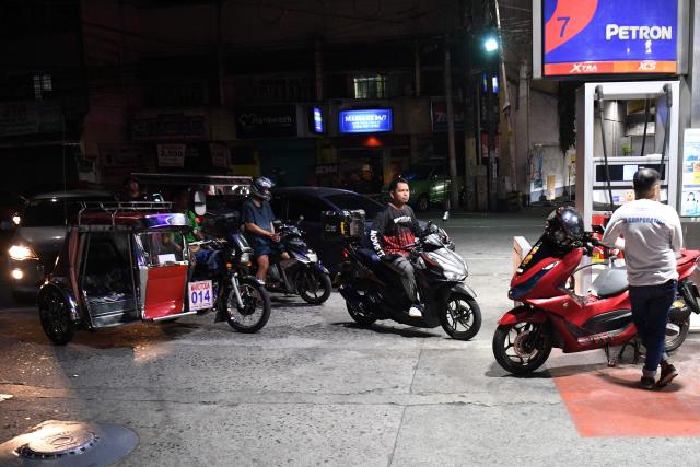 Motorists queue up prior to a fuel price increase at a petrol station in Manila on March 17, 2026. Oil climbed again in Asia on March 17 after prices retreated a day earlier, with investors remaining focused on the Strait of Hormuz. (Photo by Ted ALJIBE / AFP)