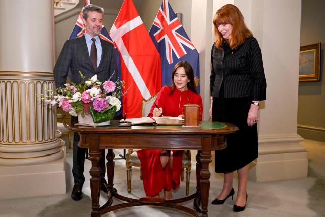 Denmark's Queen Mary (C) signs the visitor's book alongside King Frederik X and Victoria's Governor Margaret Garner at Government House in Melbourne on March 17, 2026. (Photo by William WEST / POOL / AFP)