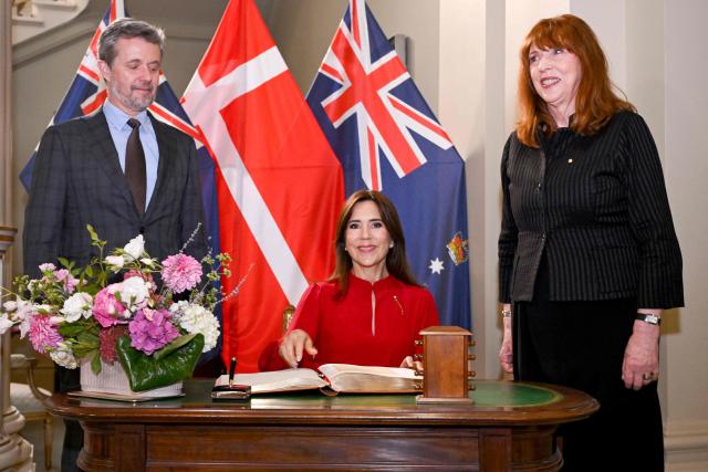 Denmark's Queen Mary (C) signs the visitor's book alongside King Frederik X and Victoria's Governor Margaret Garner at Government House in Melbourne on March 17, 2026. (Photo by William WEST / POOL / AFP)