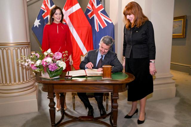 Denmark's King Frederik X (C) signs the visitor's book alongside Queen Mary (L) and Victoria's Governor Margaret Garner at Government House in Melbourne on March 17, 2026. (Photo by William WEST / POOL / AFP)