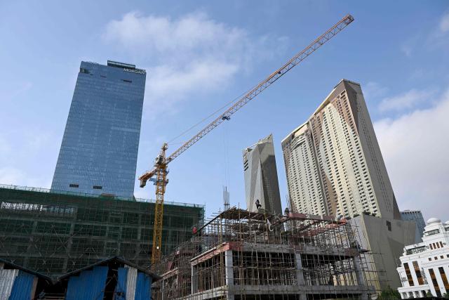 Workers are seen on a building under construction in Phnom Penh on March 17, 2026. (Photo by TANG CHHIN Sothy / AFP)
