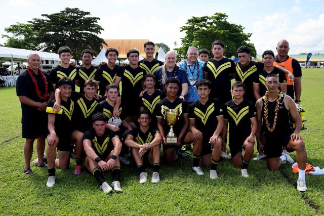 New Zealand’s Prime Minister Christopher Luxon (C) poses for photos with rugby players from Auckland’s Tipene College before their Prime Ministers Cup match against  Samoa's Wesley College in the village of Faleula, Samoa, on March 17, 2026. (Photo by Ben STRANG / AFP)