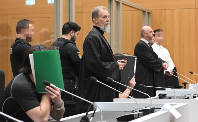 Three Ukrainian defendants, who are accused for plotting to send exploding parcels from Germany to Ukraine on the orders of a Russian intelligence service, wait for the start of their trial in the courtroom of the higher regional court in Stuttgart-Stammheim, southern Germany on March 17, 2026. Three Ukrainians go on trial in Germany, for allegedly  plotting sabotage attacks in Germany and Ukraine as part of what Berlin calls a campaign of Russian "hybrid" operations.
The suspects are accused of trying to send parcels that would "ignite in Germany or elsewhere on their way to parts of Ukraine not occupied by Russia". (Photo by THOMAS KIENZLE / AFP) / / EDITORS NOTE:  According to court's ruling the face of the judiciary officers and defendants should be made unrecognizable
