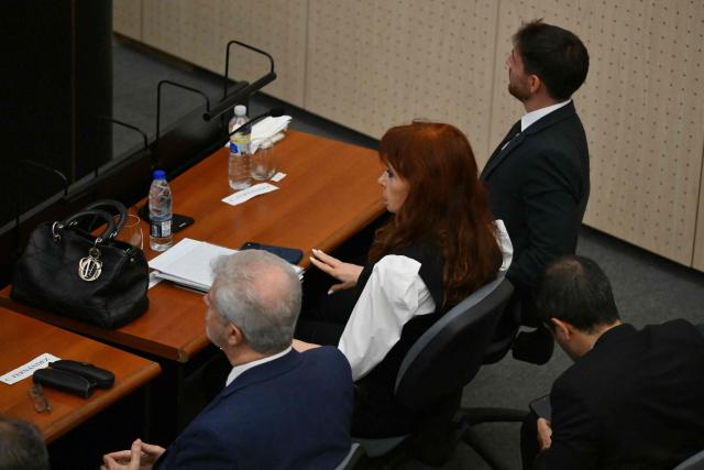 Former Argentine president (2007–2015) Cristina Kirchner (C) sits next to her lawyers at the Comodoro Py courthouse in Buenos Aires on March 17, 2026. Kirchner is set to appear before the court for questioning in the “Notebooks of Corruption” case. (Photo by Luis ROBAYO / AFP)