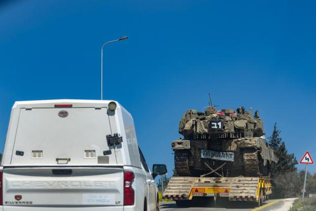 A tank is transported on a flatbed truck along the Lebanon border in the Upper Galilee, in northern Israel, on March 17, 2026. The Lebanese military said on March 17, that an Israeli strike on a car and a motorcycle in southern Lebanon killed one of its soldiers and wounded four others. Israel has stepped up strikes and deployed ground troops to its northern neighbour since March 2, when Lebanon was dragged into the wider war in the Middle East after Tehran ally Hezbollah attacked Israel with rockets in retaliation for the killing of Iranian supreme leader. (Photo by Odd ANDERSEN / AFP) / 