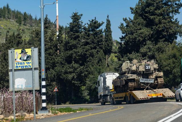 A tank is transported on a flatbed truck along the Lebanon border in the Upper Galilee, in northern Israel, on March 17, 2026. The Lebanese military said on March 17, that an Israeli strike on a car and a motorcycle in southern Lebanon killed one of its soldiers and wounded four others. Israel has stepped up strikes and deployed ground troops to its northern neighbour since March 2, when Lebanon was dragged into the wider war in the Middle East after Tehran ally Hezbollah attacked Israel with rockets in retaliation for the killing of Iranian supreme leader. (Photo by Odd ANDERSEN / AFP) / 
