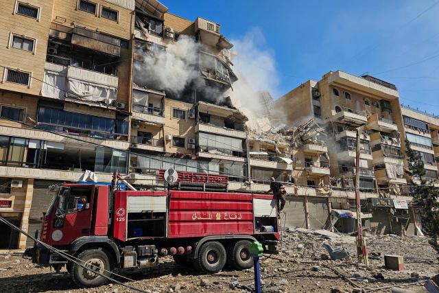 TOPSHOT - Firefighters work at the site of an Israeli airstrike in the southern suburbs of Beirut on March 17, 2026. Israel has stepped up strikes and deployed ground troops to its northern neighbour since March 2, when Lebanon was dragged into the wider war in the Middle East after Tehran ally Hezbollah attacked Israel with rockets in retaliation for the killing of Iranian supreme leader Ali Khamenei. (Photo by AFP) / 