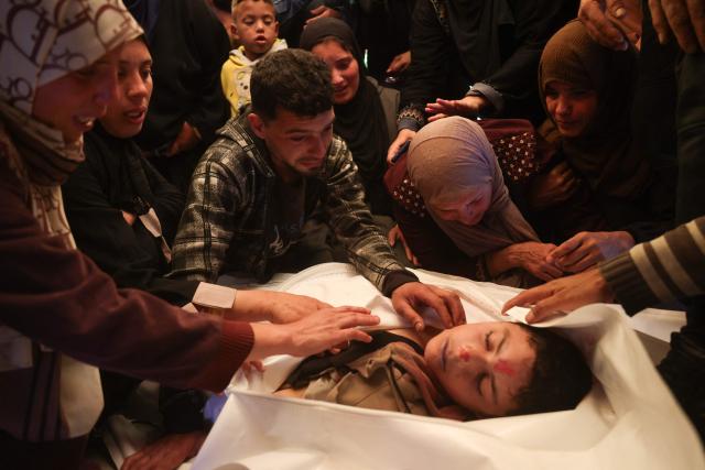 EDITORS NOTE: Graphic content / Displaced Palestinians mourn over the body of a child who was reportedly killed by an Israeli strike, at the Nasser Hospital in Khan Yunis, in the southern Gaza Strip on March 17. 2026. Despite a US-brokered truce that entered its second phase last month, violence has continued in the Palestinian territory, with Israel and Hamas blaming each other for violating the agreement. (Photo by Bashar Taleb / AFP)