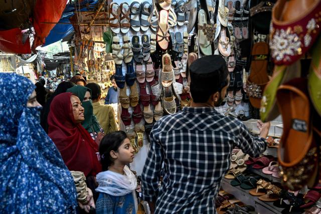 Muslim women shop for footwear at a store for the Eid al-Fitr celebrations during the last week of the Islamic holy fasting month of Ramadan in Karachi on March 17, 2026. (Photo by Rizwan TABASSUM / AFP)