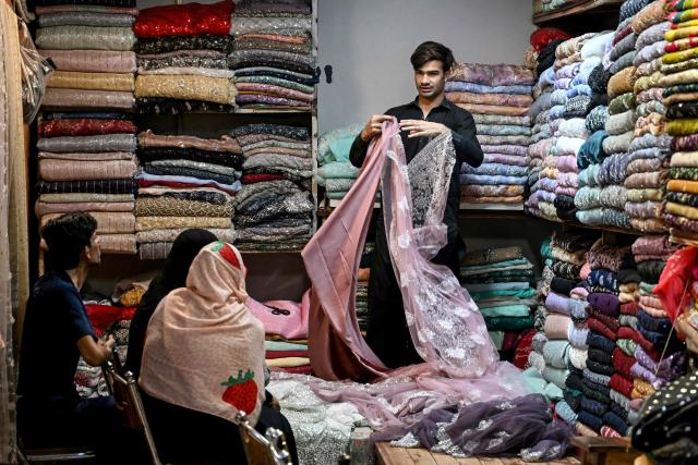 Muslims shop for apparels at a store for the Eid al-Fitr celebrations during the last week of the Islamic holy fasting month of Ramadan in Karachi on March 17, 2026. (Photo by Rizwan TABASSUM / AFP)