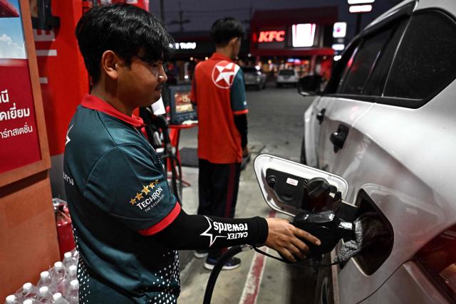 An employee refuels a vehicle at a Caltex petrol station in the northern Thai province of Chiang Rai on March 17, 2026, following import disruptions caused by the Middle East war. Oil prices rose again on March 17 as Iran launched fresh attacks on crude-producing neighbours, while stock markets were higher ahead of key central bank meetings. (Photo by Lillian SUWANRUMPHA / AFP)