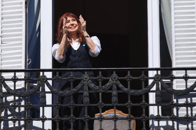 Former Argentine president (20072015) Cristina Kirchner gestures from the balcony of her home in Buenos Aires upon her arrival after being questioned at the Comodoro Py courthouse on March 17, 2026. Kirchner, sentenced to six years in prison for corruption, appeared in court in connection with another case in which she is accused of being part of an alleged bribery network involving politicians and businesspeople in the 2000s. The 73-year-old former president has been serving a six-year prison sentence under house arrest since last June and is wearing an electronic tag. (Photo by Emiliano Lasalvia / AFP)