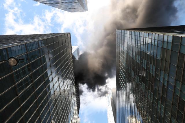 Fire and heavy smoke are seen at a high-rise building in Midtown Manhattan near the St. Patrick’s Day Parade route in New York City on March 17, 2026. (Photo by TIMOTHY A.CLARY / AFP)