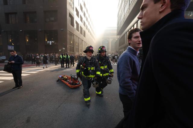Firefighters from New York Fire Department (NYFD) work at the scene as fire and heavy smoke are seen at a high-rise building in Midtown Manhattan near the St. Patrick’s Day Parade route in New York City on March 17, 2026. (Photo by TIMOTHY A.CLARY / AFP)