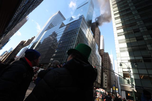 Fire and heavy smoke are seen at a high-rise building in Midtown Manhattan near the St. Patrick’s Day Parade route in New York City on March 17, 2026. (Photo by TIMOTHY A.CLARY / AFP)