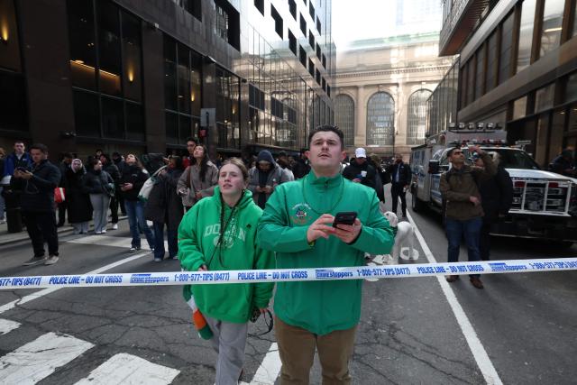 People watch as fire and heavy smoke rise from a high-rise building in Midtown Manhattan near the St. Patrick’s Day Parade route in New York City on March 17, 2026. (Photo by TIMOTHY A.CLARY / AFP)