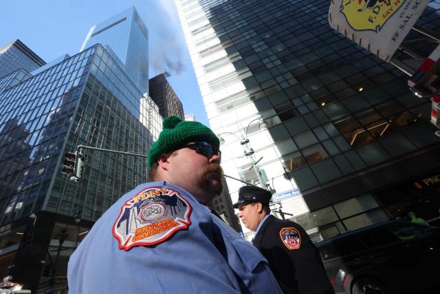 Firefighters from New York Fire Department (NYFD) are seen as fire and heavy smoke are seen at a high-rise building in Midtown Manhattan near the St. Patrick’s Day Parade route in New York City on March 17, 2026. (Photo by TIMOTHY A.CLARY / AFP)