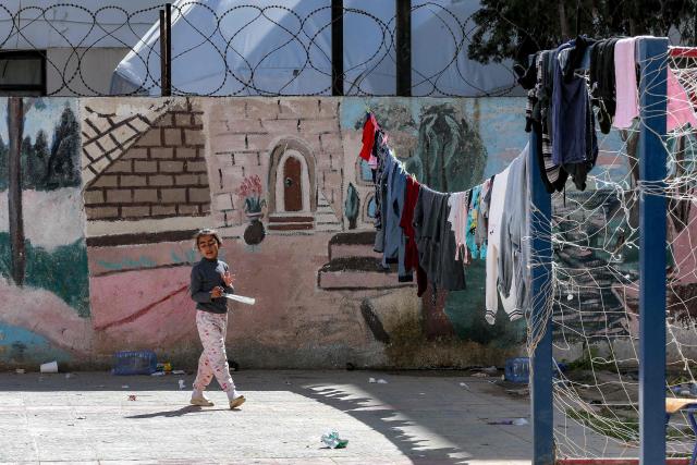 A displaced girl from southern Lebanon walks in the courtyard of a school turned into a shelter in the southern coastal city of Sidon on March 17, 2026. After being forced to flee from Israeli air raids on southern Lebanon, families search in vain for alternative accommodations amid strict measures imposed by hotels and landlords afraid that guests might be targeted by Israel. In two weeks of war, Israel has carried out surprise strikes on two hotels, as well as on buildings in densely populated residential neighbourhoods. (Photo by MAHMOUD ZAYYAT / AFP)