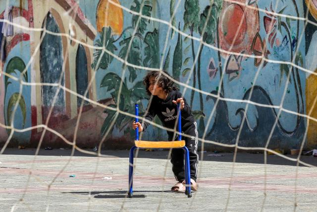 A displaced child from southern Lebanon plays in the courtyard of a school turned into a shelter in the southern coastal city of Sidon on March 17, 2026. After being forced to flee from Israeli air raids on southern Lebanon, families search in vain for alternative accommodations amid strict measures imposed by hotels and landlords afraid that guests might be targeted by Israel. In two weeks of war, Israel has carried out surprise strikes on two hotels, as well as on buildings in densely populated residential neighbourhoods. (Photo by MAHMOUD ZAYYAT / AFP)