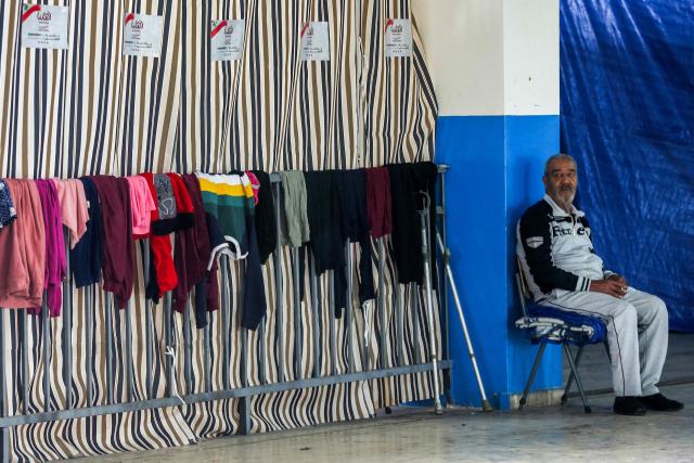 A displaced elderly man from southern Lebanon, sits in the courtyard of a school turned into a shelter in the southern coastal city of Sidon on March 17, 2026. After being forced to flee from Israeli air raids on southern Lebanon, families search in vain for alternative accommodations amid strict measures imposed by hotels and landlords afraid that guests might be targeted by Israel. In two weeks of war, Israel has carried out surprise strikes on two hotels, as well as on buildings in densely populated residential neighbourhoods. (Photo by MAHMOUD ZAYYAT / AFP)