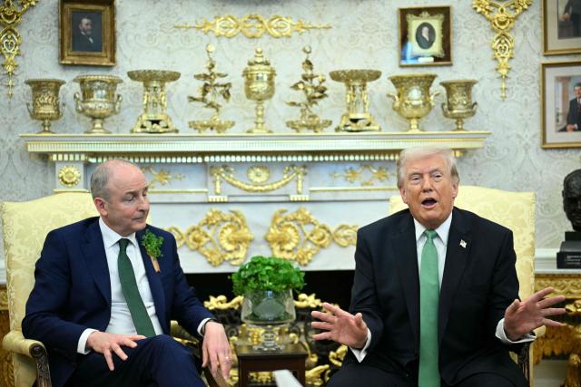 Irish Prime Minster Micheal Martin  listens to US President Donald Trump during their bilateral meeting in the Oval Office of the White House in Washington, DC, on March 17, 2026. The Irish prime minister arrived in the United States March 13 for an annual St Patrick's Day trip under pressure to talk tough to US President Donald Trump amid the Iran war. (Photo by Jim WATSON / AFP)