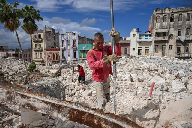 A man collects materials to sell from the rubble of the National School of Design in Havana on March 16, 2026. Cuba scrambled on March 17, 2026, to restore power after a nationwide blackout that hit the communist-run island just as US President Donald Trump proclaimed he will "take" it over. (Photo by YAMIL LAGE / AFP)