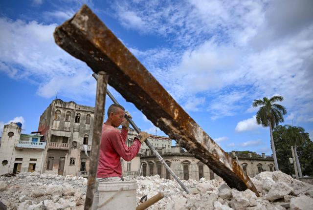 A man collects materials to sell from the rubble of the National School of Design in Havana on March 16, 2026. Cuba scrambled on March 17, 2026, to restore power after a nationwide blackout that hit the communist-run island just as US President Donald Trump proclaimed he will "take" it over. (Photo by YAMIL LAGE / AFP)