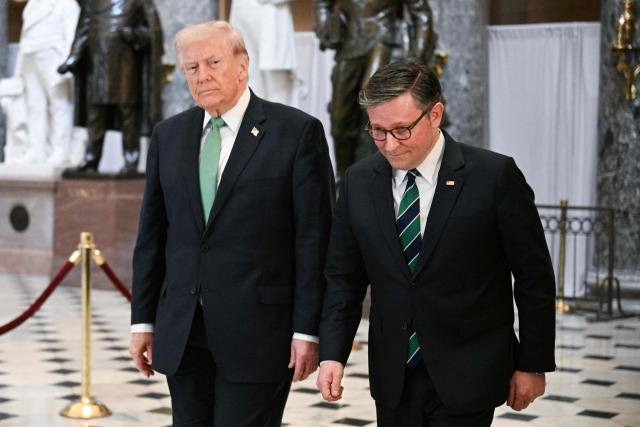 US President Donald Trump and US Speaker of the House Mike Johnson, Republican from Louisiana walk through the Statuary Hall on Capitol Hill after a Friends of Ireland luncheon in Washington, DC on March 17, 2026. (Photo by Jim WATSON / AFP)
