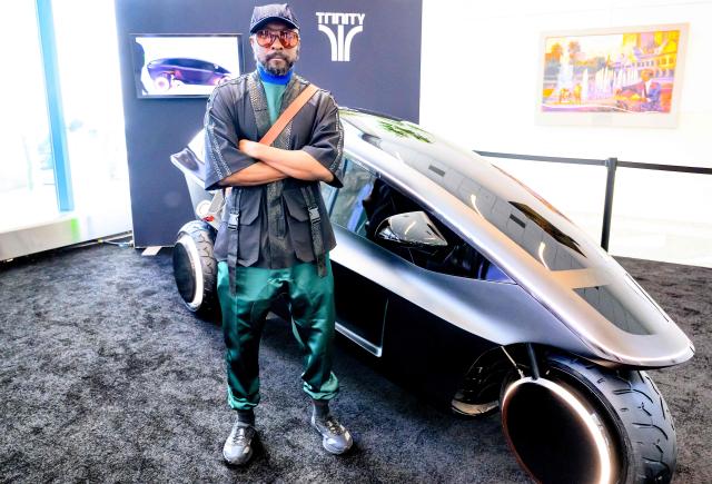 US musician and tech entrepreneur Will.i.am stands for a photo in front of Trinity, an electric, AI-powered three-wheeled vehicle during NVidia's annual GTC developers conference in San Jose, California, on March 17, 2026. (Photo by JOSH EDELSON / AFP)