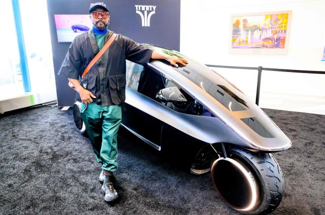 US musician and tech entrepreneur Will.i.am stands for a photo in front of Trinity, an electric, AI-powered three-wheeled vehicle during NVidia's annual GTC developers conference in San Jose, California, on March 17, 2026. (Photo by JOSH EDELSON / AFP)