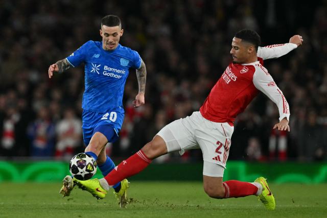 Bayer Leverkusen's Spanish defender #20 Alejandro Grimaldo (L) is tackled by Arsenal's French defender #02 William Saliba (R) during the UEFA Champions League, last 16 second leg football match between Arsenal and Bayer Leverkusen at the Emirates Stadium in north London on March 17, 2026. (Photo by Glyn KIRK / AFP)
