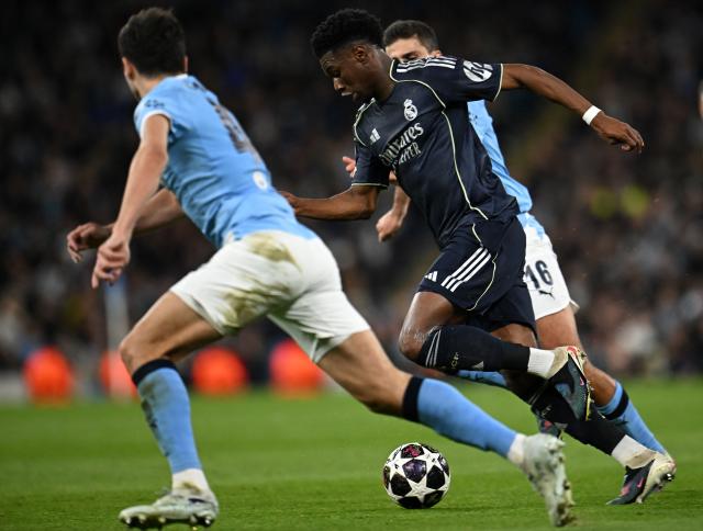 Real Madrid's French midfielder #14 Aurelien Tchouameni (C) runs with the ball during the UEFA Champions League, round of 16 second leg football match between Manchester City and Real Madrid at the Etihad Stadium in Manchester, north west England, on March 17, 2026. (Photo by Paul ELLIS / AFP)