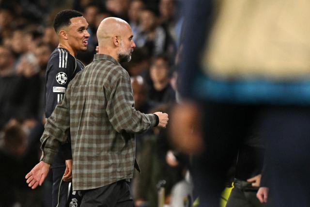 Real Madrid's English defender #12 Trent Alexander-Arnold (L) talks with Manchester City's Spanish manager Pep Guardiola at half-time during the UEFA Champions League, round of 16 second leg football match between Manchester City and Real Madrid at the Etihad Stadium in Manchester, north west England, on March 17, 2026. (Photo by Oli SCARFF / AFP)