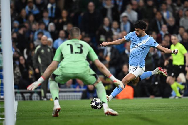 Manchester City's Portuguese midfielder #27 Matheus Nunes (R) crosses the ball during the UEFA Champions League, round of 16 second leg football match between Manchester City and Real Madrid at the Etihad Stadium in Manchester, north west England, on March 17, 2026. (Photo by Paul ELLIS / AFP)