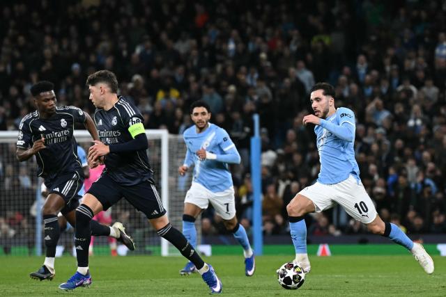 Manchester City's French midfielder #10 Rayan Cherki (R) runs with the ball during the UEFA Champions League, round of 16 second leg football match between Manchester City and Real Madrid at the Etihad Stadium in Manchester, north west England, on March 17, 2026. (Photo by Paul ELLIS / AFP)