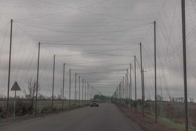 A car drives on a road covered with anti-drone netting to protect against drone attacks in the Kharkiv region on March 17, 2026, amid the Russian invasion of Ukraine. (Photo by Roman PILIPEY / AFP)