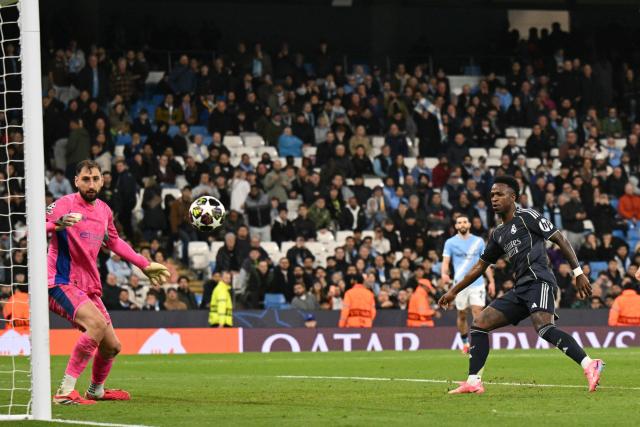 Real Madrid's Brazilian forward #07 Vinicius Junior (R) scores their late second goal during the UEFA Champions League, round of 16 second leg football match between Manchester City and Real Madrid at the Etihad Stadium in Manchester, north west England, on March 17, 2026. (Photo by Oli SCARFF / AFP)