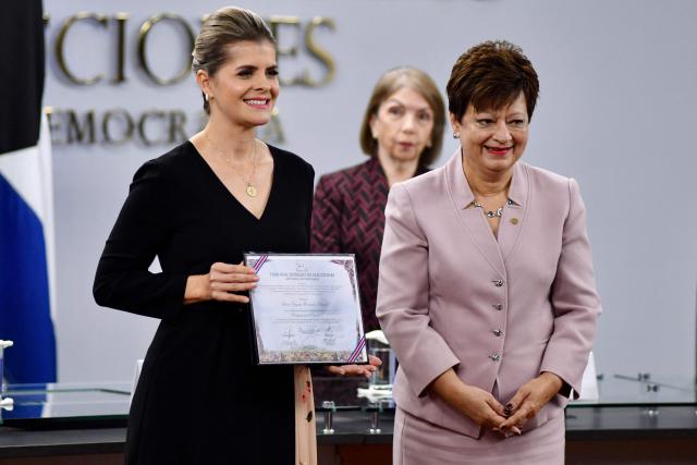 TOPSHOT - The president of the Supreme Electoral Tribunal, Eugenia Zamora (R), hands over the credentials to the president-elect of Costa Rica Laura Fernandez during a ceremony at the Supreme Electoral Tribunal (TSE) in San Jose on March 17, 2026. (Photo by Ezequiel BECERRA / AFP)