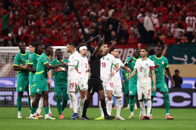 (FILES) Congolese referee Jean-Jacques Ndala Ngambo calls for a VAR decision during the Africa Cup of Nations (CAN) final football match between Senegal and Morocco at the Prince Moulay Abdellah Stadium in Rabat on January 18, 2026. Senegal was stripped of its Africa Cup of Nations title by the Confederation of African Football (CAF) over its players' walk-off during the final, with Morocco declared champions, CAF announced on March 17, 2026. CAF confirmed the appeal by the Royal Moroccan Football Federation was upheld, overturning the earlier CAF Disciplinary Board decision that had allowed Senegal to keep their victory. (Photo by FRANCK FIFE / AFP)