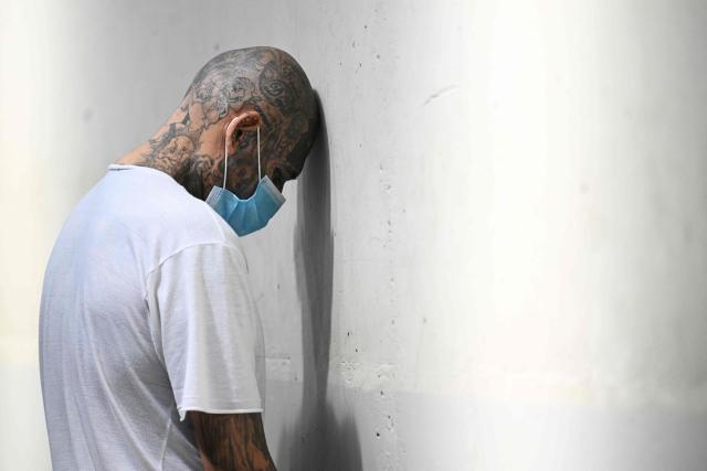 (FILES) An inmate remain in a cell at the Counter-Terrorism Confinement Centre (CECOT) mega-prison, where hundreds of members of the MS-13 and 18 Street gangs are being held, in Tecoluca, El Salvador on January 27, 2025. Salvadoran lawmakers on March 17, 2026 passed a constitutional reform proposed by iron-fisted President Nayib Bukele to allow sentences of life imprisonment for "murderers, rapists and terrorists." (Photo by Marvin RECINOS / AFP)