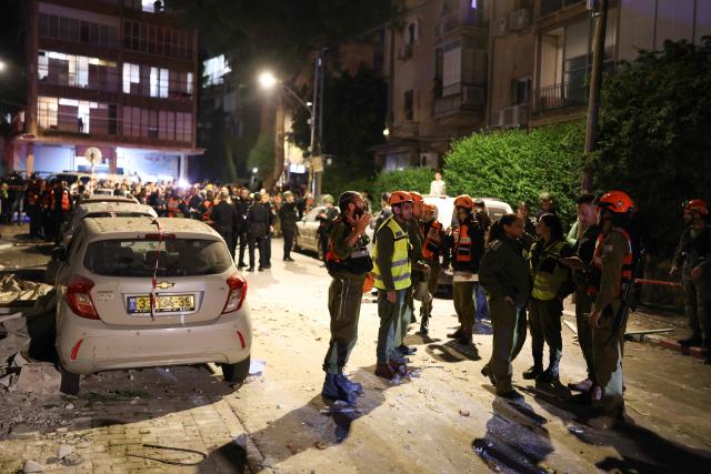 First responders inspect the damage at the site of a missile strike in Ramat Gan, in the outskirts of Tel-Aviv, Israel on March 18, 2026. (Photo by Ilia YEFIMOVICH / AFP)